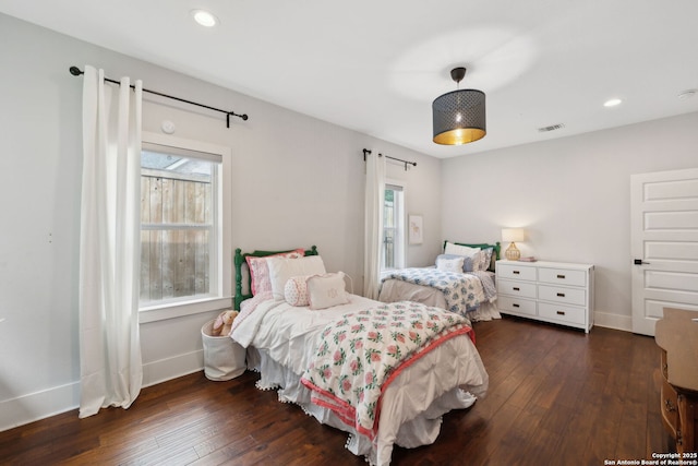 bedroom with baseboards, dark wood-style floors, and multiple windows