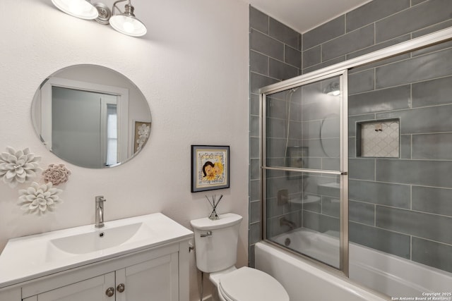 full bath featuring vanity, combined bath / shower with glass door, and toilet