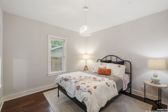 bedroom with baseboards and wood finished floors