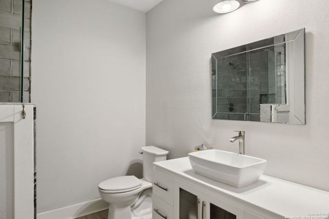 full bath featuring vanity, toilet, and tiled shower