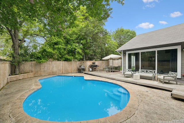 view of swimming pool with a fenced in pool, a fenced backyard, outdoor dining area, and a deck
