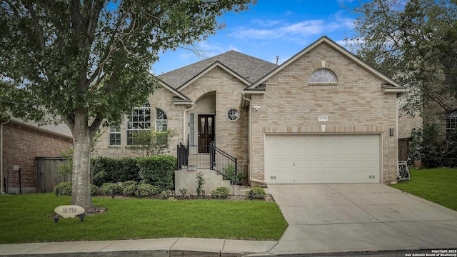 view of front of property featuring brick siding, an attached garage, driveway, and a front yard