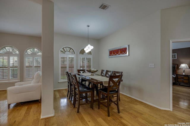 dining space with baseboards, light wood finished floors, a healthy amount of sunlight, and visible vents