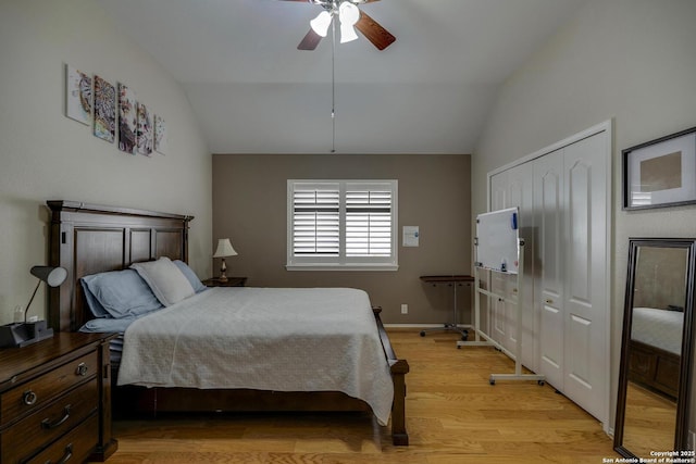 bedroom featuring ceiling fan, vaulted ceiling, light wood-style flooring, and a closet