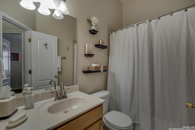 bathroom with toilet, a chandelier, and vanity
