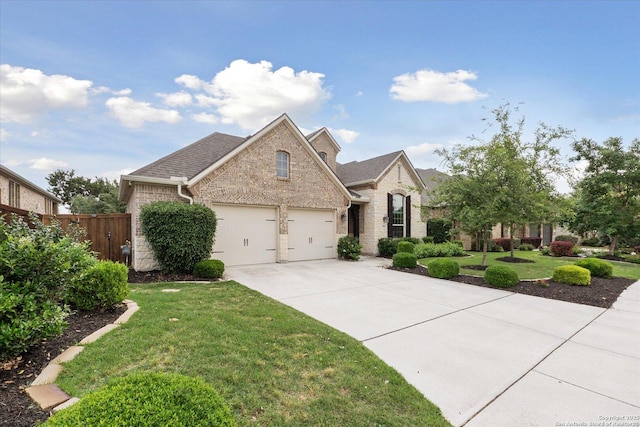 view of front of property with fence, stone siding, a garage, a front yard, and concrete driveway