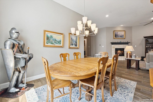 dining room featuring an inviting chandelier, a fireplace, recessed lighting, baseboards, and wood finished floors