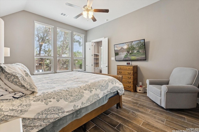 bedroom featuring ceiling fan, visible vents, lofted ceiling, and wood tiled floor