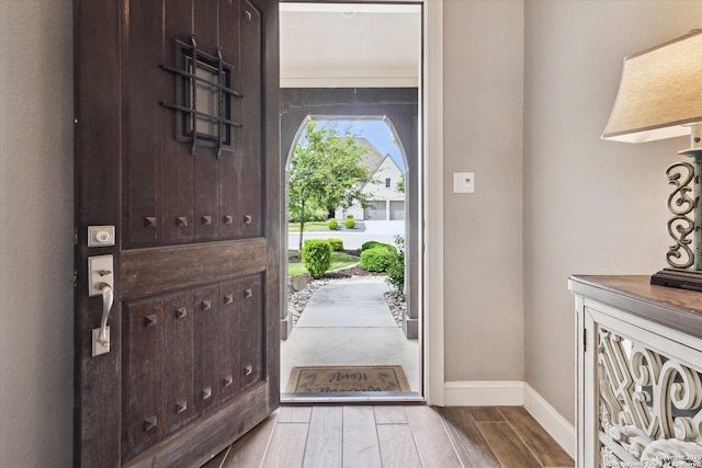 foyer entrance with baseboards and wood finished floors