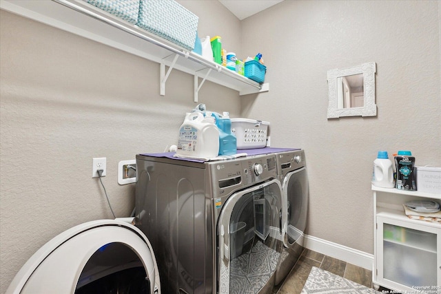 laundry area featuring separate washer and dryer, laundry area, baseboards, and wood finished floors