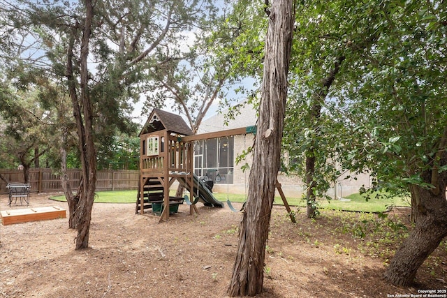 view of jungle gym with a sunroom and fence