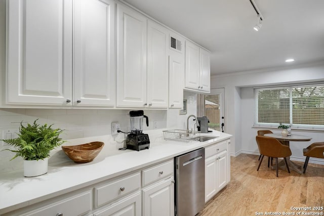 kitchen with visible vents, stainless steel dishwasher, a sink, light wood finished floors, and white cabinetry