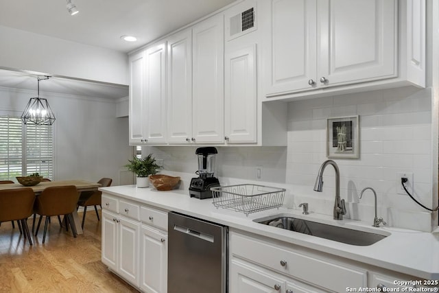 kitchen with stainless steel dishwasher, visible vents, white cabinetry, a sink, and a notable chandelier