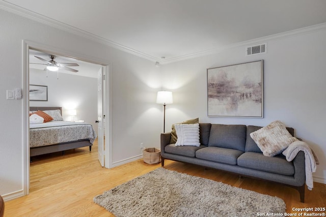 living room featuring visible vents, ornamental molding, and wood finished floors
