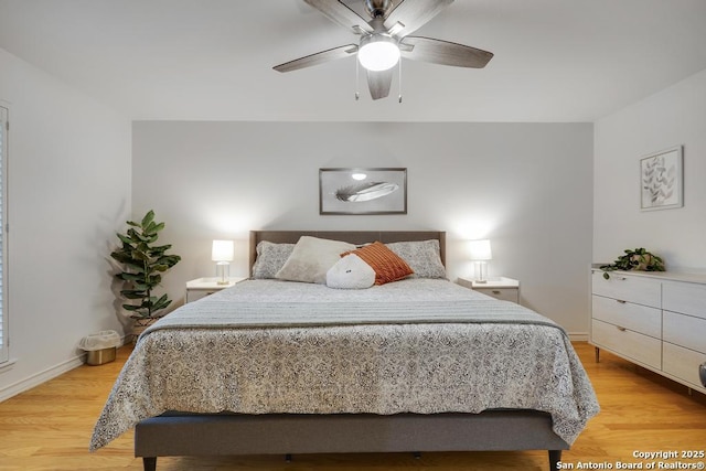 bedroom with light wood-type flooring, a ceiling fan, and baseboards