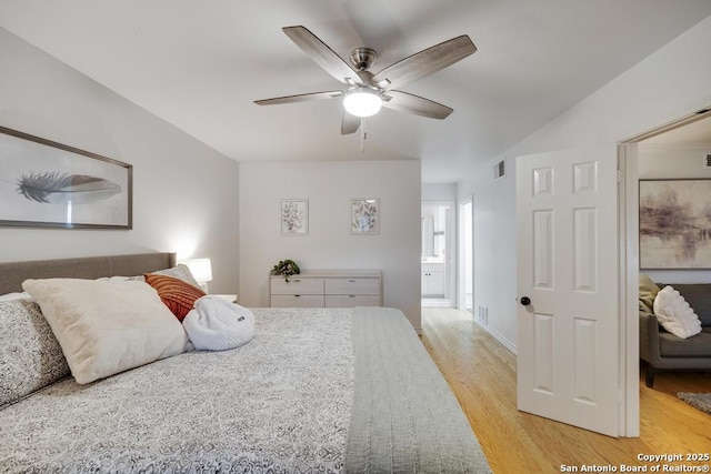 bedroom with visible vents, a ceiling fan, ensuite bath, and light wood-type flooring