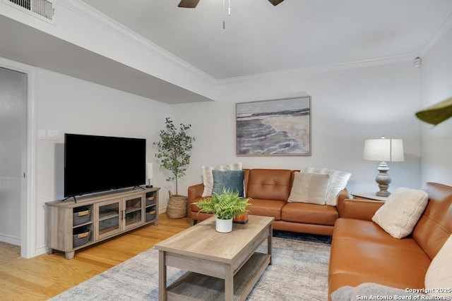 living room with ceiling fan, visible vents, ornamental molding, and wood finished floors