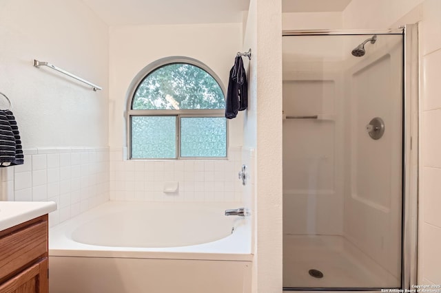 full bath featuring vanity, a garden tub, and a shower stall