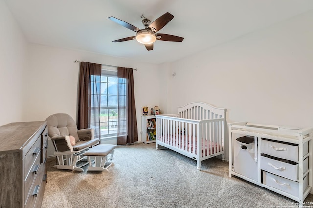 bedroom featuring carpet floors, a ceiling fan, and a nursery area