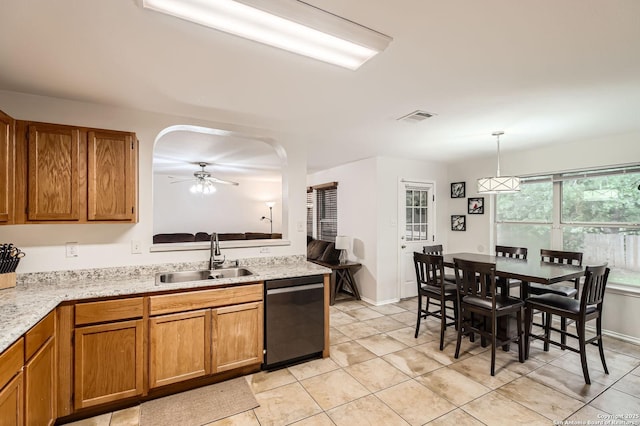 kitchen with visible vents, stainless steel dishwasher, brown cabinets, a sink, and light tile patterned floors