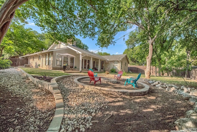 13402 Vista Del Mar, San Antonio, TX 78216 - back of house with a fire pit, a fenced backyard, a chimney, brick siding, and a lawn