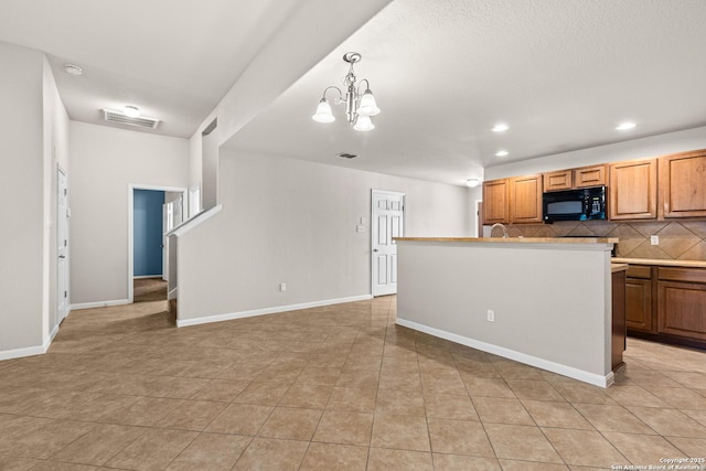 kitchen with decorative backsplash, black microwave, light tile patterned floors, a notable chandelier, and recessed lighting