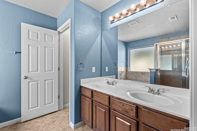 bathroom featuring visible vents, a sink, double vanity, and a shower stall