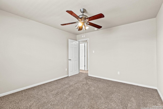 carpeted empty room featuring baseboards and ceiling fan