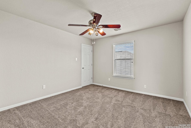 spare room featuring ceiling fan, visible vents, baseboards, and carpet