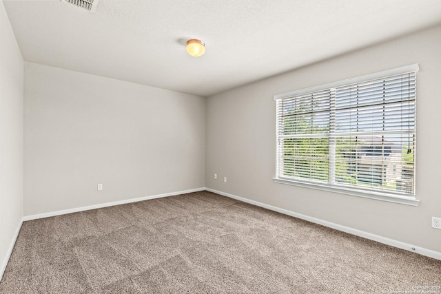unfurnished room featuring carpet floors, baseboards, and visible vents