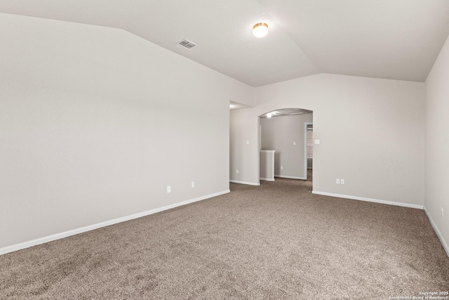 carpeted empty room with visible vents, arched walkways, baseboards, and lofted ceiling