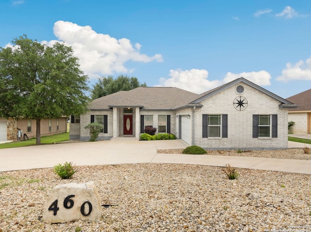 ranch-style house featuring a garage, driveway, and brick siding