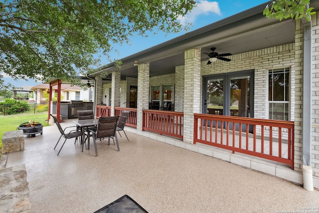 view of patio / terrace with a ceiling fan, outdoor dining space, and an outdoor fire pit