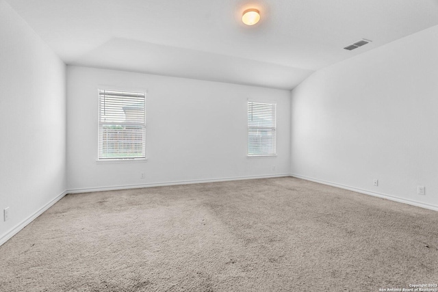 empty room featuring carpet floors, visible vents, and a wealth of natural light