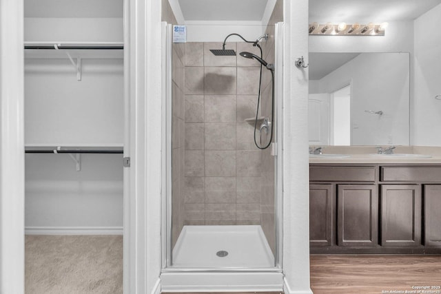bathroom with double vanity, a sink, and a stall shower