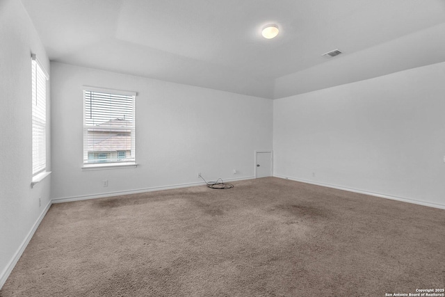 carpeted spare room featuring visible vents and baseboards