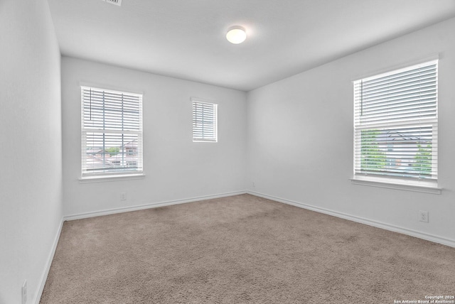 empty room featuring carpet flooring and baseboards