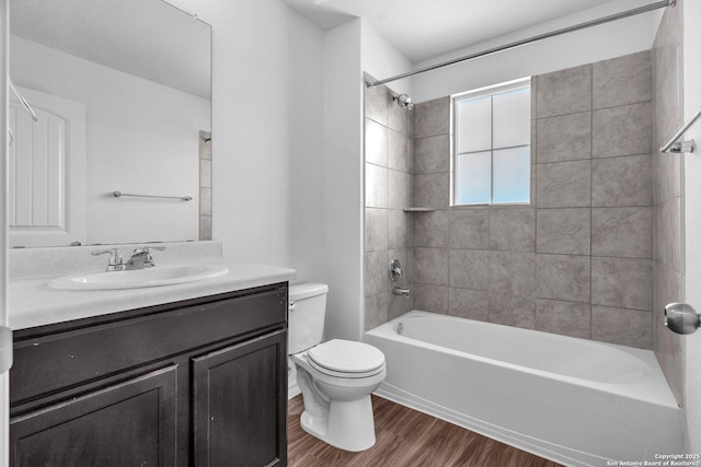 bathroom with toilet, tub / shower combination, wood finished floors, and vanity