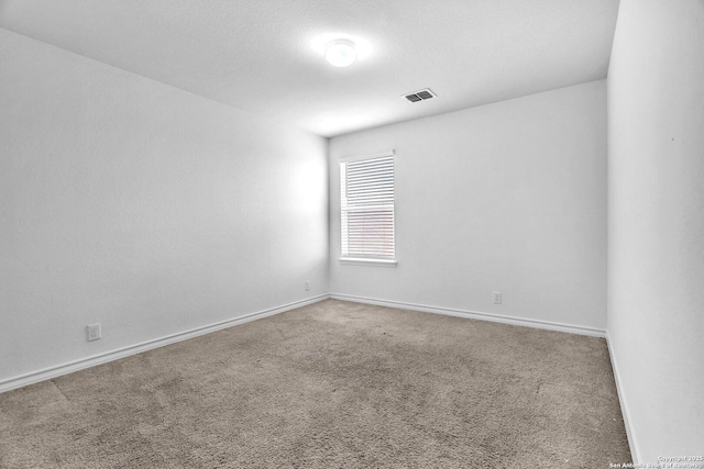 carpeted empty room with baseboards and visible vents