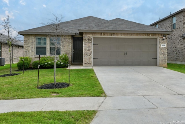 view of front of house featuring a front lawn, brick siding, concrete driveway, an attached garage, and central air condition unit