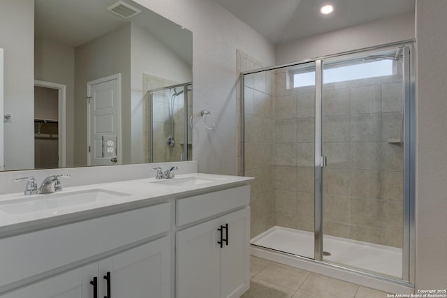 full bath with visible vents, a sink, a stall shower, and tile patterned flooring