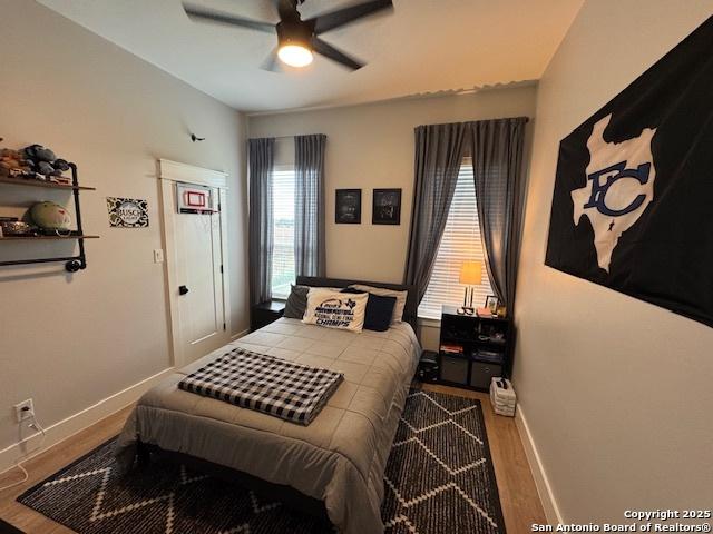 bedroom featuring baseboards, ceiling fan, and wood finished floors