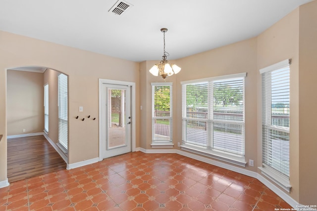 29303 Sumpter Dr, Boerne, TX 78015 - unfurnished dining area with arched walkways, baseboards, visible vents, and an inviting chandelier