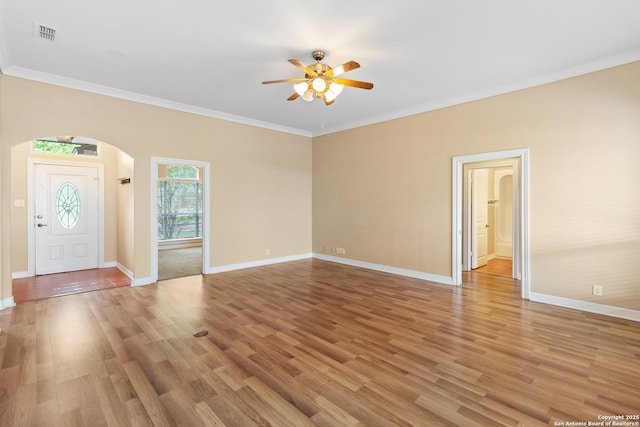 29303 Sumpter Dr, Boerne, TX 78015 - unfurnished living room featuring crown molding, arched walkways, ceiling fan, and baseboards