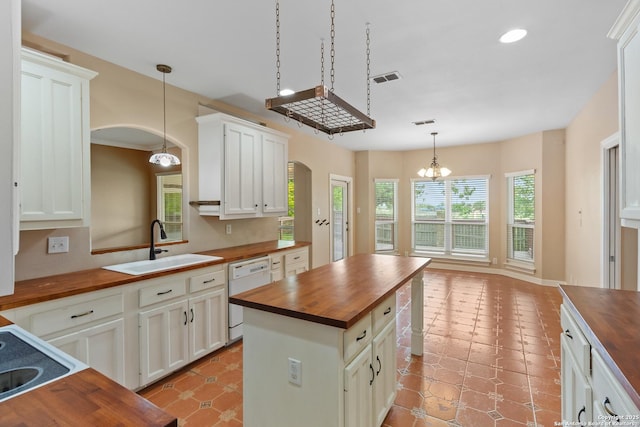 29303 Sumpter Dr, Boerne, TX 78015 - kitchen featuring an inviting chandelier, butcher block countertops, arched walkways, a sink, and dishwasher