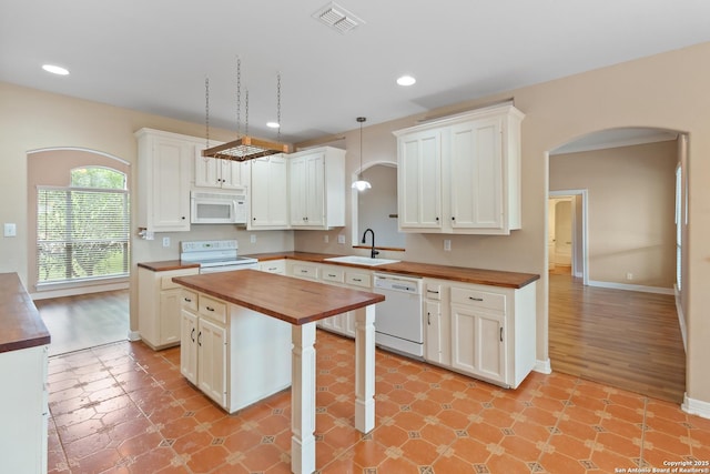 29303 Sumpter Dr, Boerne, TX 78015 - kitchen with visible vents, wooden counters, white appliances, arched walkways, and a sink
