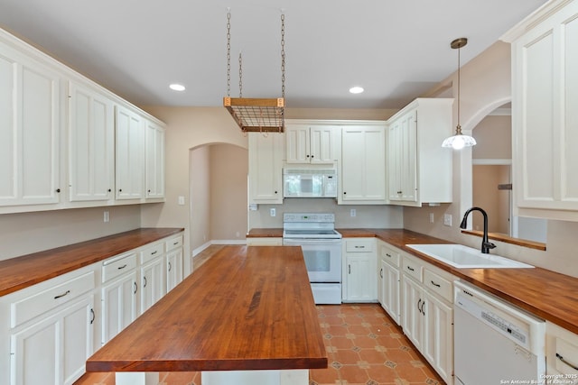 29303 Sumpter Dr, Boerne, TX 78015 - kitchen featuring white appliances, arched walkways, butcher block countertops, and a sink