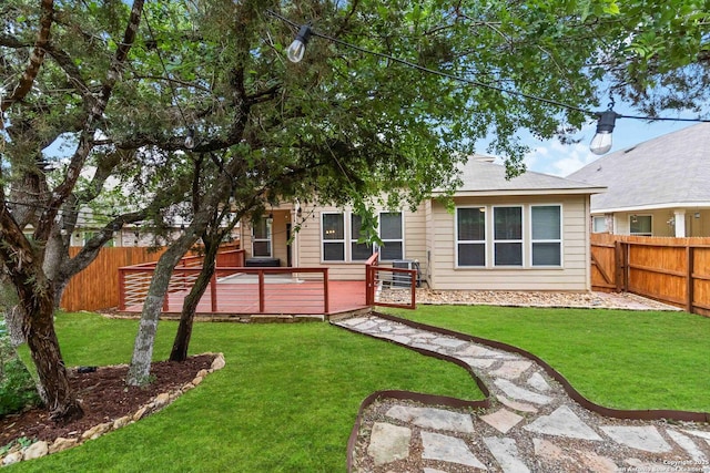 back of house featuring a fenced backyard, a yard, and a deck