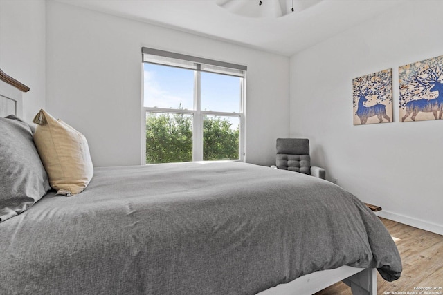 bedroom with baseboards and wood finished floors