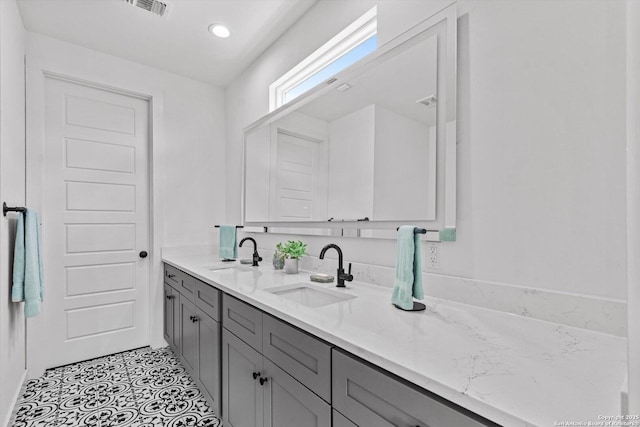 bathroom with double vanity, visible vents, a sink, and tile patterned flooring